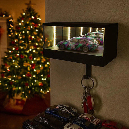 Key holder with model cars on a wall hook in front of a Christmas tree